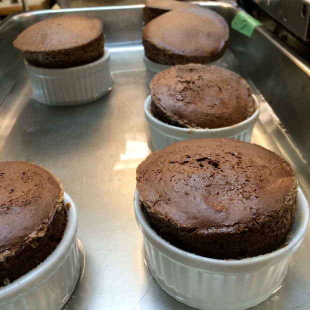 Souffles have to be plated immediately after baking time is done, or else they fall. They are quite rare on menus nowadays for this reason, the timing of getting these out to the customers is a challenge. Or else you have a fallen chocolate cake. Still tastes good, but it's not the same. 