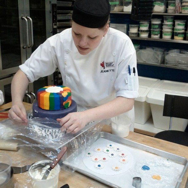 Me preparing to air brush and protecting the bottom of the cake. I learned that we should have air brushed  the colour on before we stacked the tiers... 